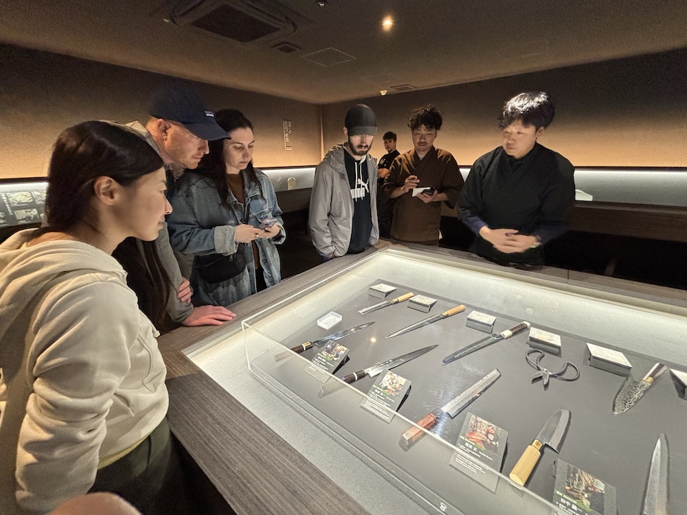 ガイドさんから包丁の展示の説明を受ける参加者