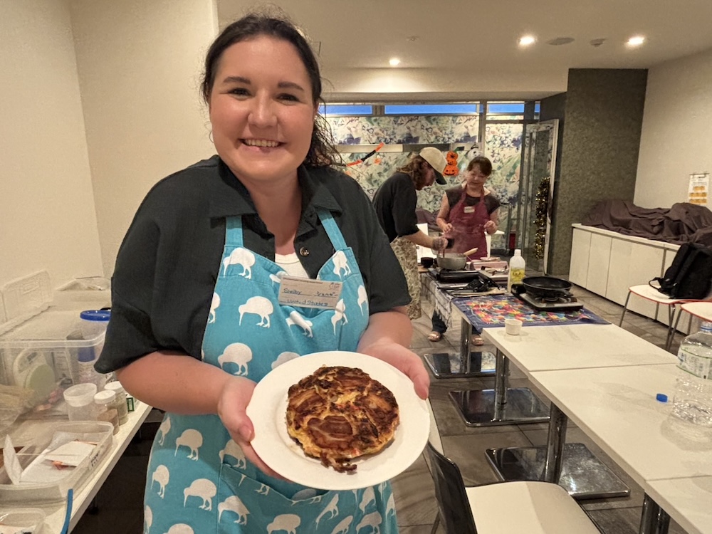 作ったお好み焼きと一緒に写真を撮る参加者